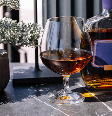 Elegant cognac pour with bottle on classy bar counter