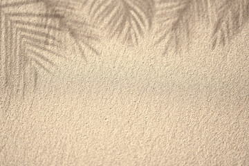 Palm leaf shadow on sand, top view, copy space. Summer background. Palm leaf shadow on sand, top view, copy space