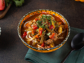 Delicious lagman soup, uzbek lagman soup, Asian cuisine, lagman soup with meat and vegetables. Lagman soup with beef, noodles, sweet peppers, onions and herbs.