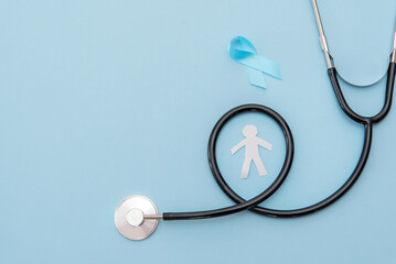 Prostate cancer awareness concept. Paper cut out man silhouette with Stethoscope and blue ribbon on...