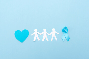 blue ribbon, heart and paper men's silhouettes on blue background, prostate cancer awareness concept