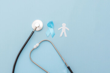 Prostate cancer blue background with Stethoscope ,blue ribbon and paper cut man silhouette