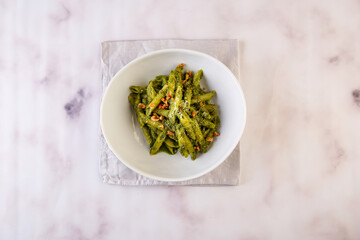 Genovese Pesto or green pasta with walnuts served in dish isolated on grey background top view of italian fastfood