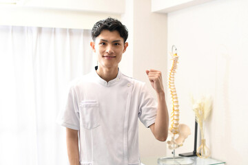 ガッツポーズする白衣姿のアジア人男性
