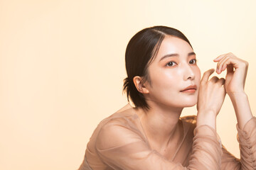 美しい女性のポートレート。彼女はベージュのオーガンジーのドレスを着て肘をつき見上げている。上品で優雅。