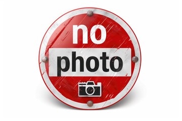 Red and white no photo sign with a camera icon on a distressed surface.
