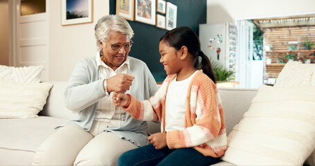 Fototapeta premium Hands, fist and stack with child, family in house for playful and fun happiness, bonding together and relax. Granny, home and girl with handshake, game and cheerful with smile, positive and break