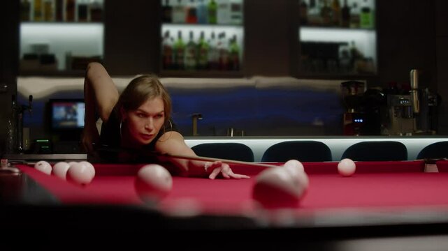 Sexy woman is enthusiastically playing Russian billiards in a night club. Mid shot. Slow motion