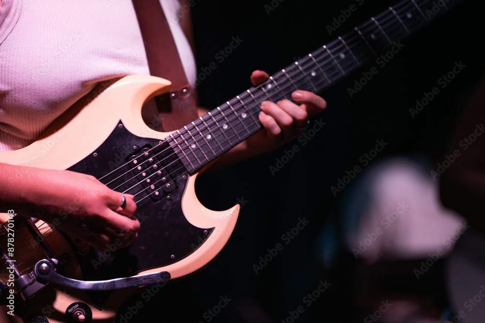 Wall mural female musician playing guitar band at a rock show to an audience watching. sound check with a switc