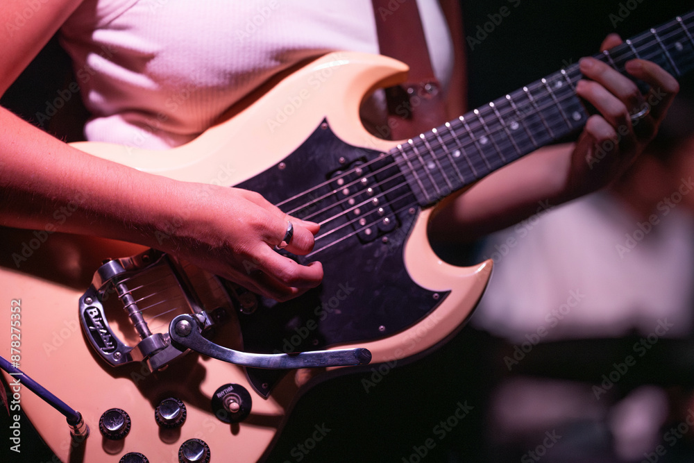 Poster female musician playing guitar band at a rock show to an audience watching. sound check with a switcher in a music venue