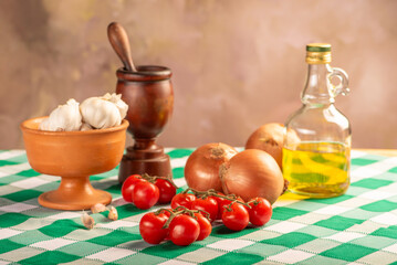 Table with ingredients and utensils on a green and white tablecloth, selective focus.