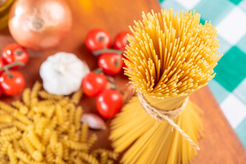 Pasta, table with pasta, ingredients and utensils, top view.