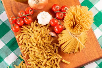 Pasta, table with pasta, ingredients and utensils, top view.