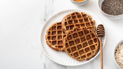 Homemade oatmeal and chia seed waffles on a white plate. Copy space