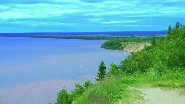 Seascape - the shore of Lake Onega against the background of clouds. Karelian landscape.Concept of traveling around the Russian North.Nature, ecology, ecotourism.Forest lake, 4K video