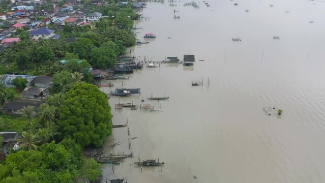 Aerial view of fishing trap net in canel with fisherman urban city village town houses, lake or river. Nature landscape fisheries and fishing tools at Pak Pha, Songkhla, Thailand. Aquaculture farming