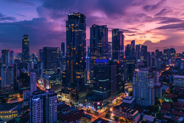Obraz premium Aerial view of vibrant cityscape with illuminated skyscrapers against dramatic sunset sky. Office buildings in downtown and glowing city streets in the night. Nightlife of modern metropolis