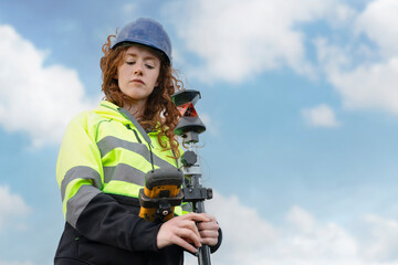 Female Construction Worker Using Surveying Equipment on Sunny Day