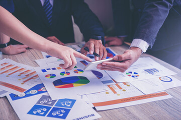 Obraz premium Business peoples using smartphone, meeting to discuss the situation on stock market, talking business plan, marketing for investment. Selected focus