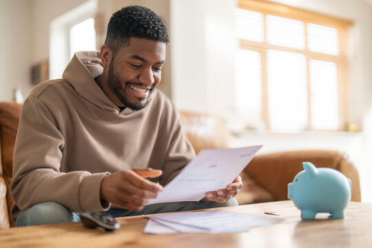 Happy Man Reviewing Bills and Finances At Home