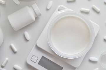 Protein Supplement and Scale on White Background