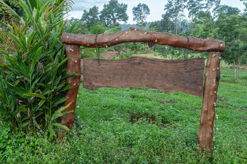 Old wooden swing and fence in a garden landscape with grass