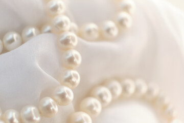 A poetic arrangement of pearls lays on a soft canvas, the blurring effect adding a touch of mystery. The scene encourages a slow, thoughtful appreciation in a fast-scrolling digital world.