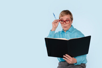 Woman Reading  Note Book While Holding Her Glasses With a Pen