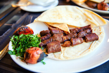 Traditional syrian kebab with pita bread, stewed tomatoes and herbs