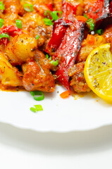 A plate of food with a lot of red peppers and onions