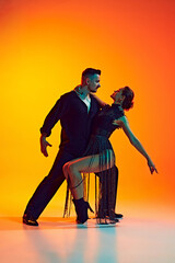 Tender and passionate. Full-length of artistic couple, men and women in elegant costumes dancing...