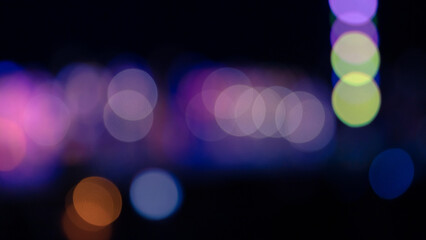 Colorful blurred lights are over black background, abstract photo. Bokeh