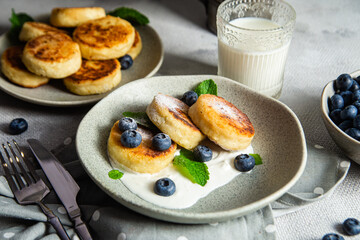 Cottage cheese pancakes with cream sauce and blueberries. syrniki 