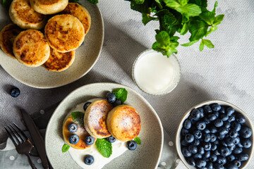 Cottage cheese pancakes with cream sauce and blueberries. syrniki 