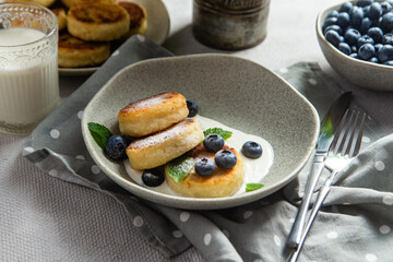 Cottage cheese pancakes with cream sauce and blueberries. syrniki 