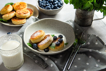 Cottage cheese pancakes with cream sauce and blueberries. syrniki 