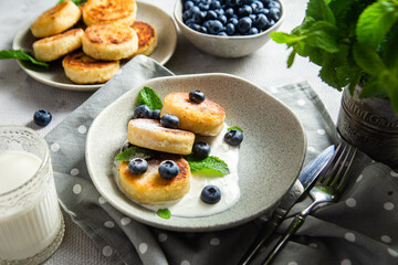 Cottage cheese pancakes with cream sauce and blueberries. syrniki 