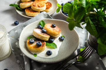 Cottage cheese pancakes with cream sauce and blueberries. syrniki 