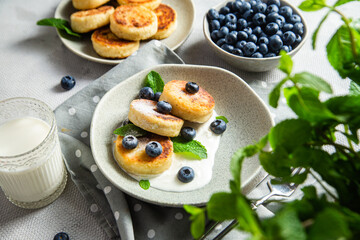 Cottage cheese pancakes with cream sauce and blueberries. syrniki 
