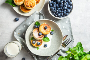 Cottage cheese pancakes with cream sauce and blueberries. syrniki 