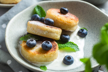 Cottage cheese pancakes with cream sauce and blueberries. syrniki 
