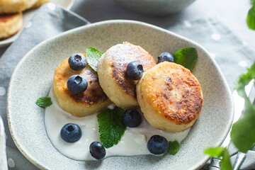 Cottage cheese pancakes with cream sauce and blueberries. syrniki 