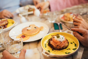 Group of millennial friends having breakfast together in a coffeeshop.