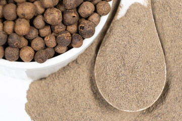 Ground black pepper and peppercorns close-up.