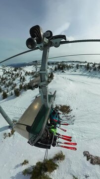 Vertical top shot following a chair lift with a skiers family during winter