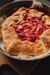 pie with strawberries on a plate, dark background, closeup