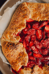pie with strawberries on a plate, dark background, closeup