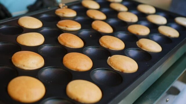 mini pancakes are cooked in a special pan at a children's party