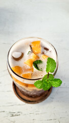 Mango iced tea with mint leaves which tastes very refreshing. Iced tea on a white table is very fresh to enjoy in the hot summer