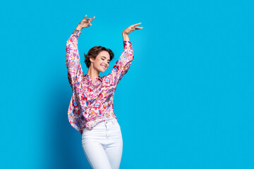 Naklejka premium Portrait of positive nice person raise arms dancing partying empty space ad isolated on blue color background
